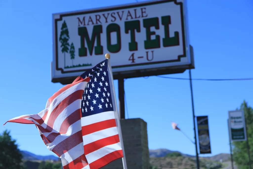 American flag waving in the foreground of the Marysvale Motel sign in the background.